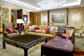 A spacious living room with a large sofa, armchairs, a glass coffee table, and a chandelier. - Crowne Plaza Tianjin Jinnan by IHG (Tianjin)