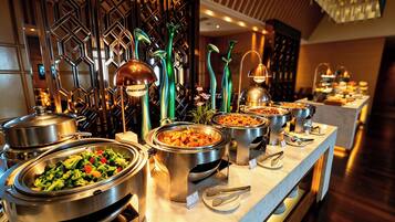 Una mesa de buffet con varios recipientes de comida y utensilios para servir.