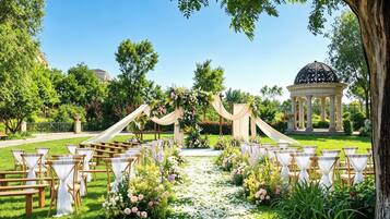An outdoor wedding venue with a clear aisle, wooden chairs, and a gazebo in the background.