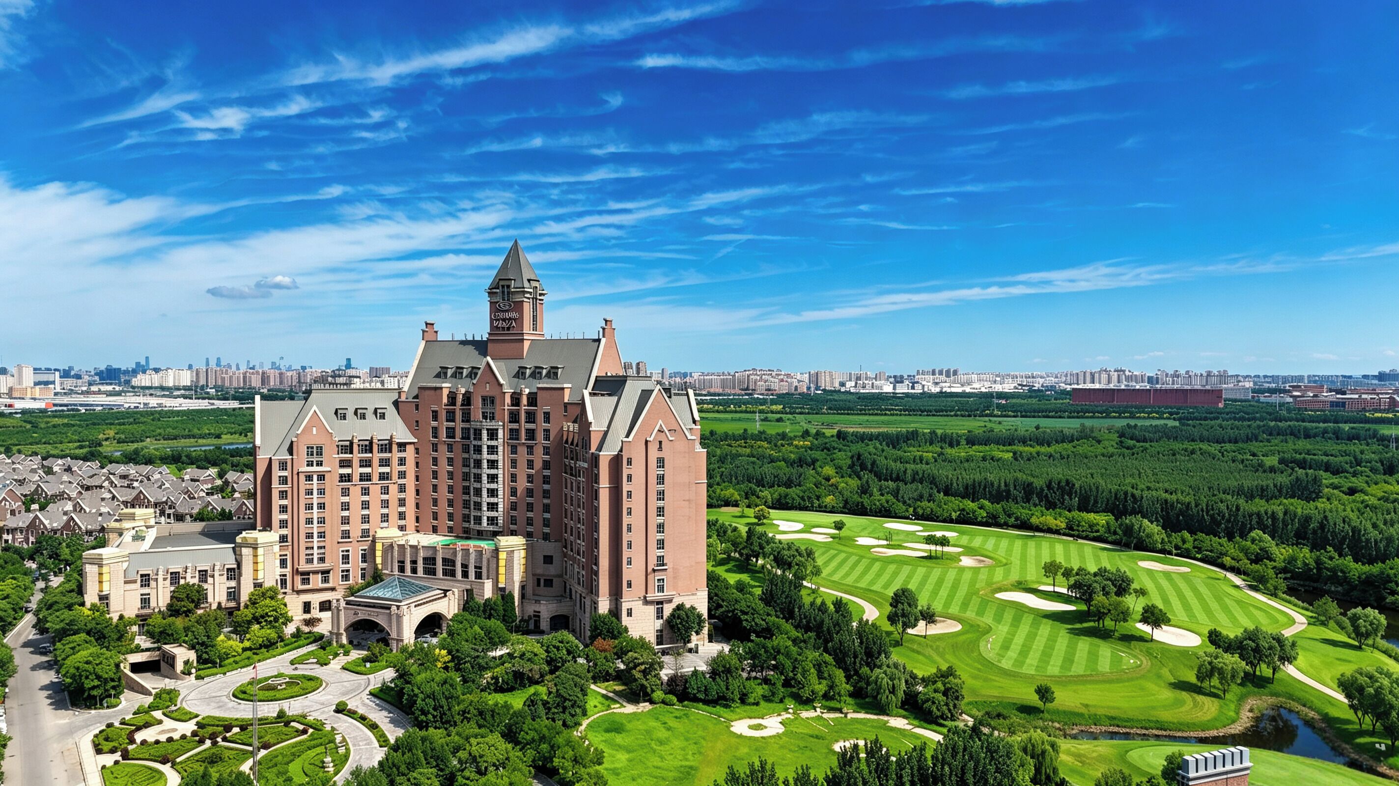 A large hotel with a prominent tower, surrounded by a well-maintained golf course and lush greenery.