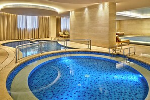 A hotel pool area with multiple swimming pools, lounge chairs, and a jacuzzi. - Crowne Plaza Tianjin Jinnan by IHG (Tianjin)
