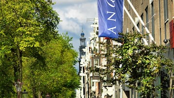 Una calle flanqueada por edificios históricos, una bandera y bicicletas aparcadas.