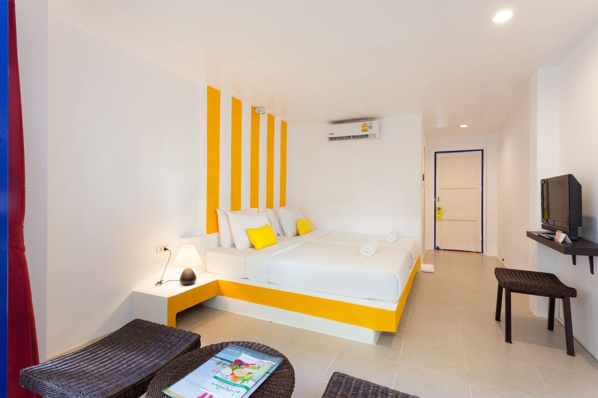 A hotel room with a bed, a television, a desk, and a chair.
