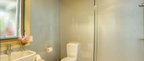 Ein Badezimmer mit Toilette, Waschbecken und einer Duschkabine aus Glas.
