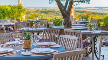 Un restaurante con terraza, mesas redondas y sillas.