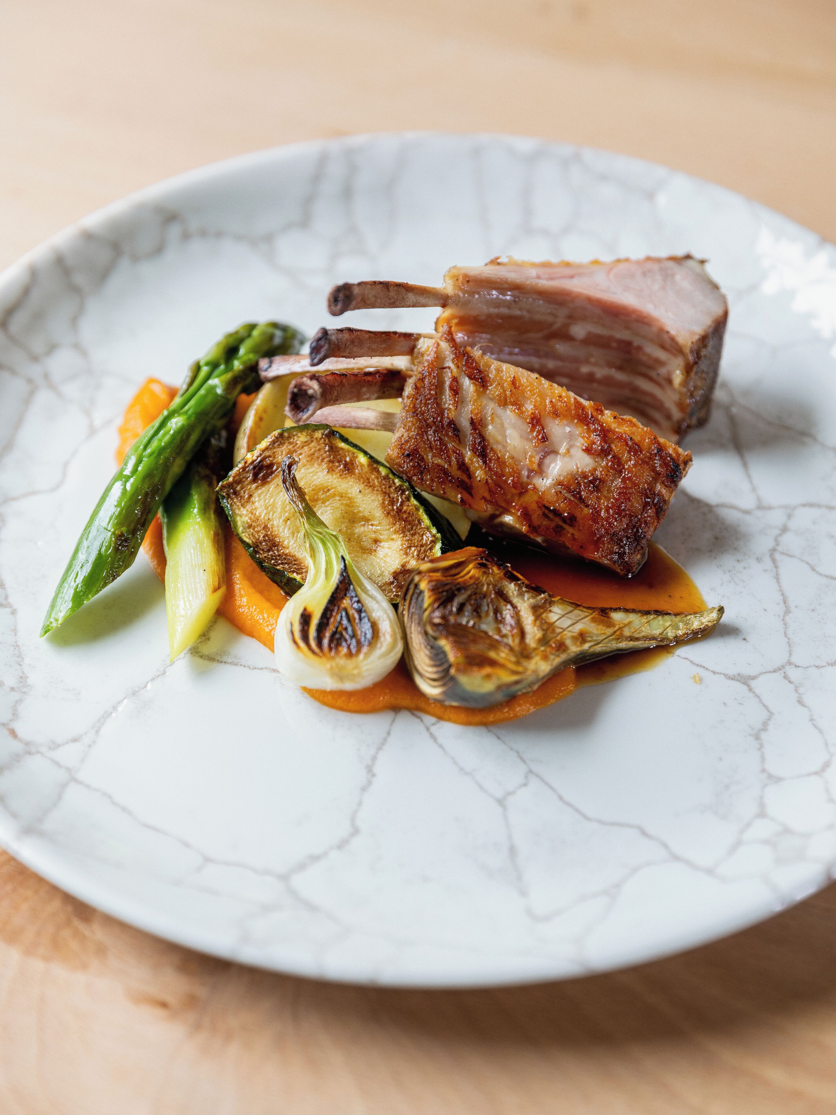 Une assiette de porc rôti accompagné de légumes.