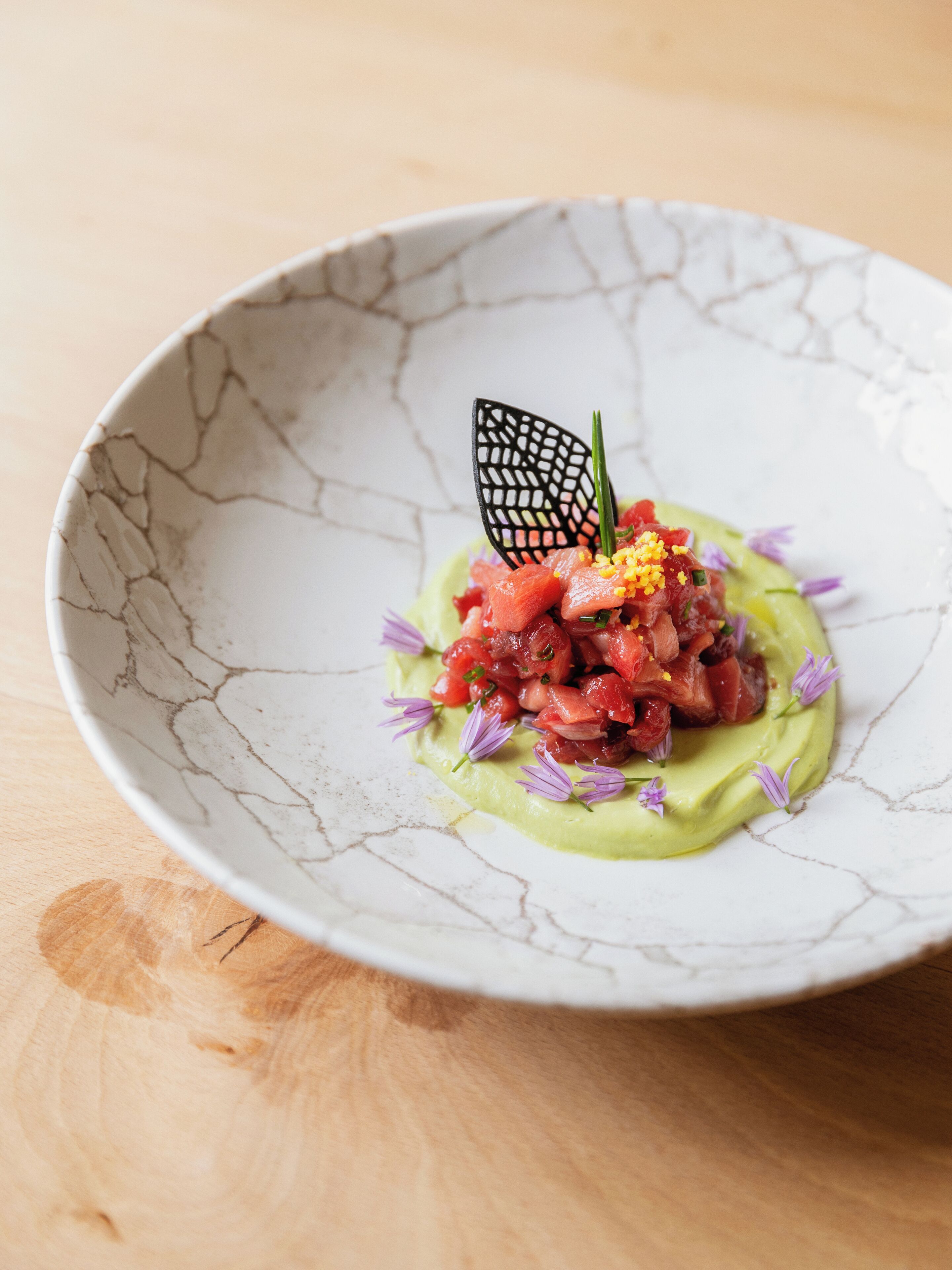 A dish with a cracked bowl on a wooden surface.