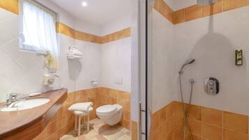 A bathroom with a sink, toilet, and shower.