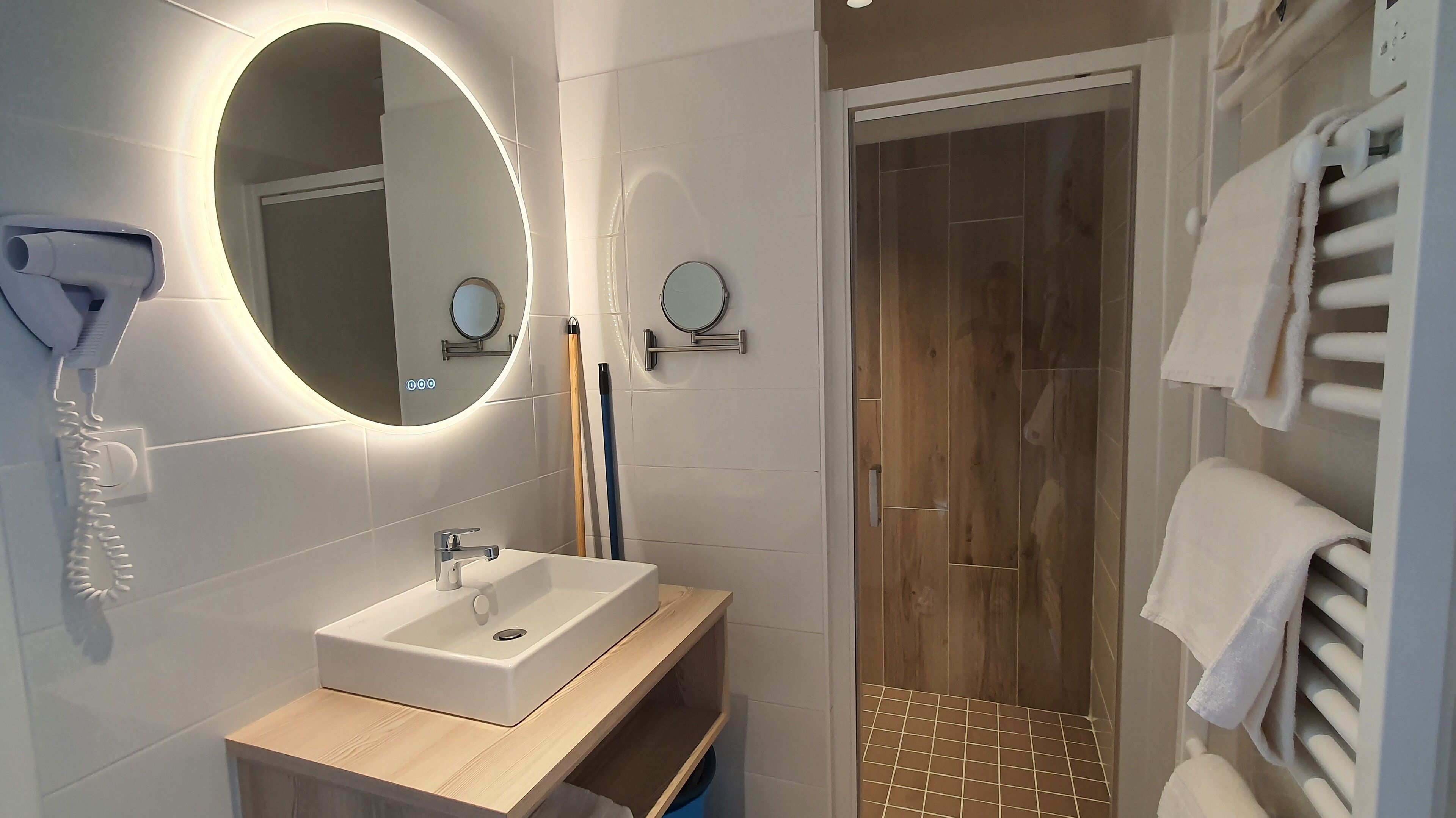 Une salle de bain moderne avec un lavabo, un miroir et un porte-serviettes.