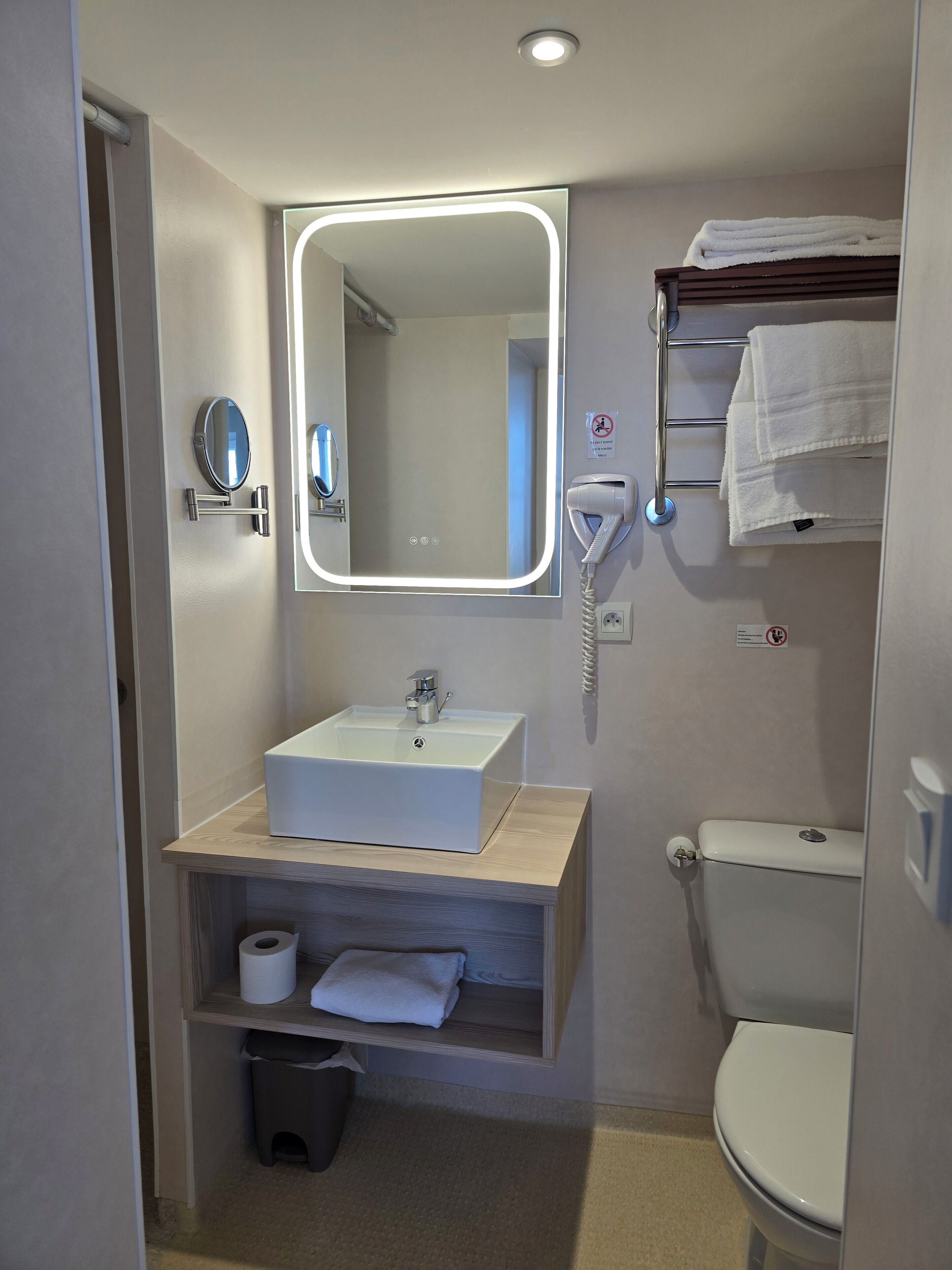 A bathroom with a sink, mirror, towel rack, and toilet.