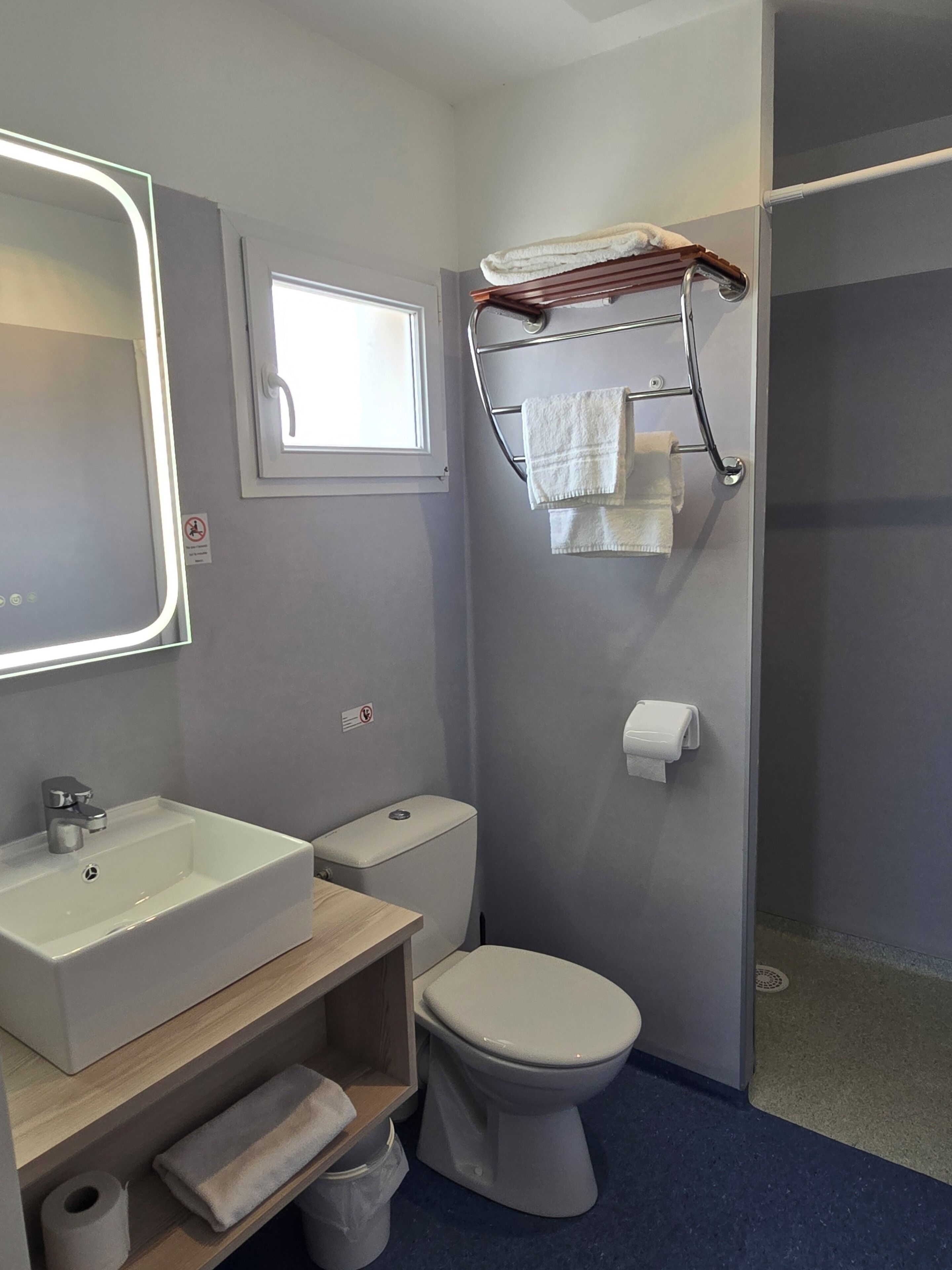 A bathroom with a white sink, toilet, and a towel rack.