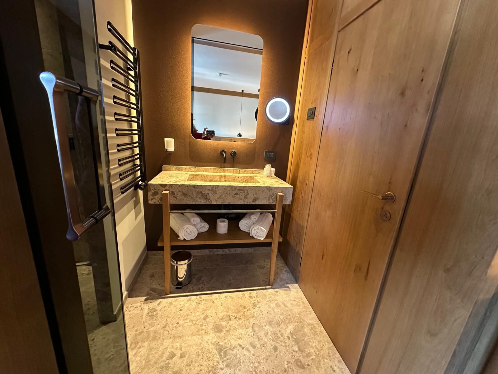 Une petite salle de bain avec un lavabo en marbre, un miroir et un meuble-lavabo en bois.