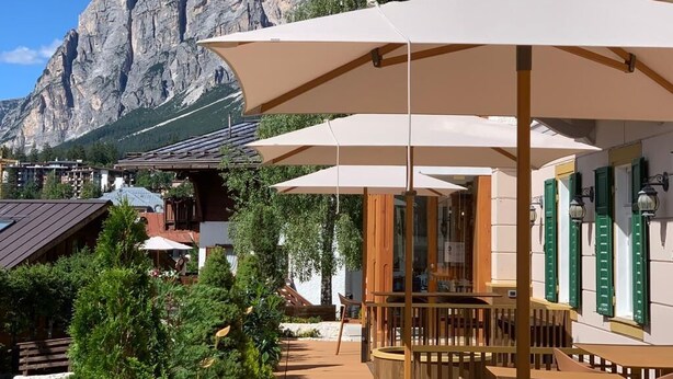 Una terraza con mobiliario exterior y montañas al fondo.