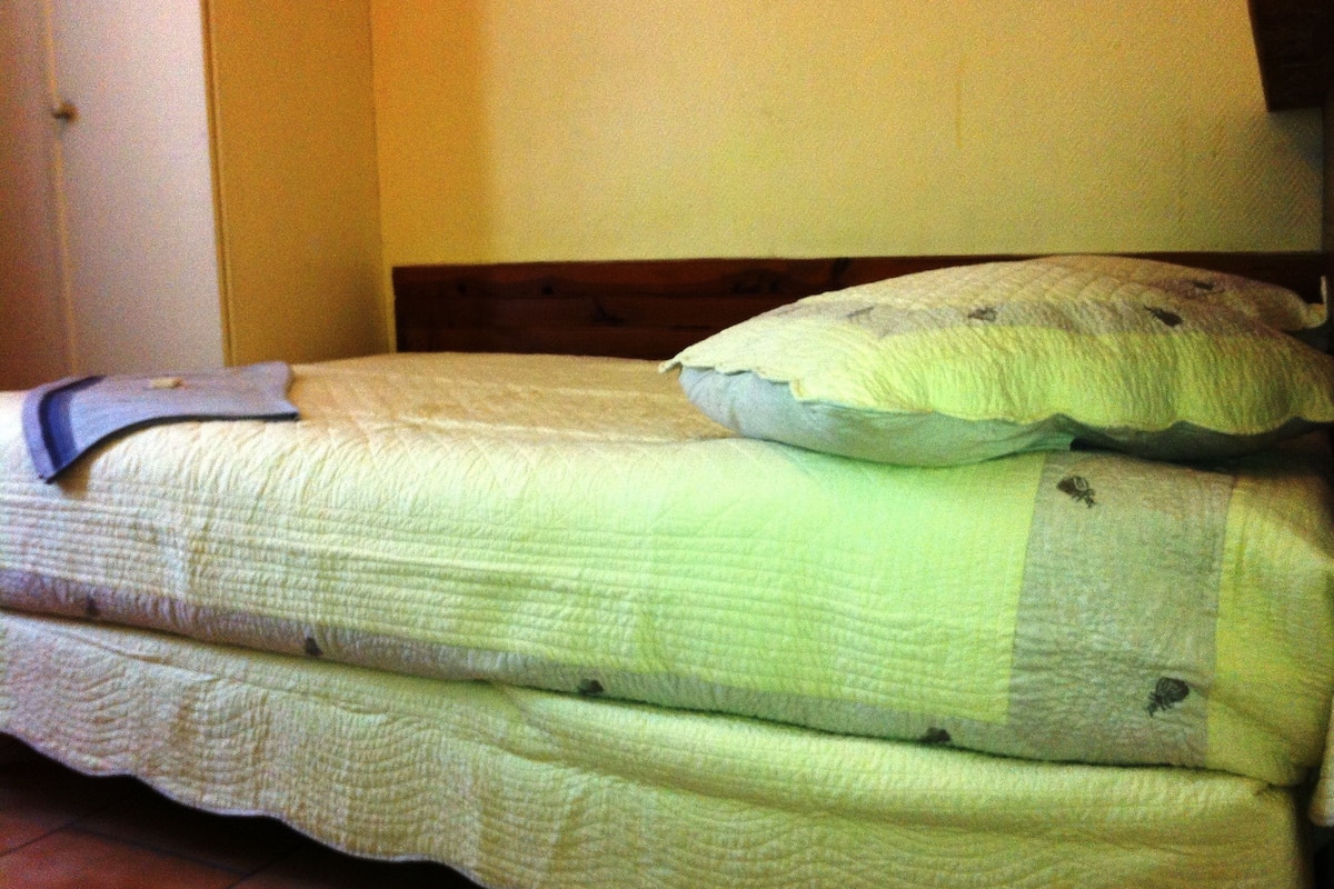 Una cama con una colcha acolchada y dos almohadas.
