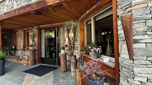 A stone building with a wooden porch and large windows. - Alpenlodge (Zermatt)