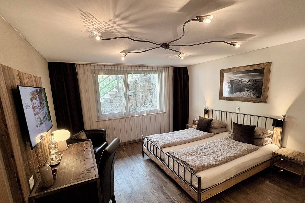 Une chambre à coucher avec un lit, une table de chevet, une lampe et un tableau au mur.