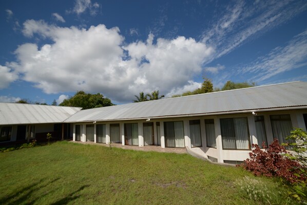 A motel with a row of rooms, each with a window and a door.