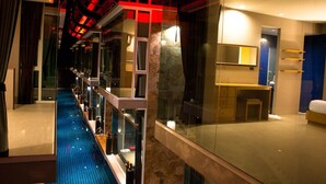 A modern hotel room with a glass-enclosed balcony, a marble floor, and a large bed. - P10 Samui (Koh Samui)