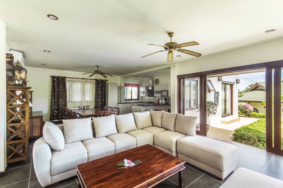 A living room with a sofa, a coffee table, and a ceiling fan.