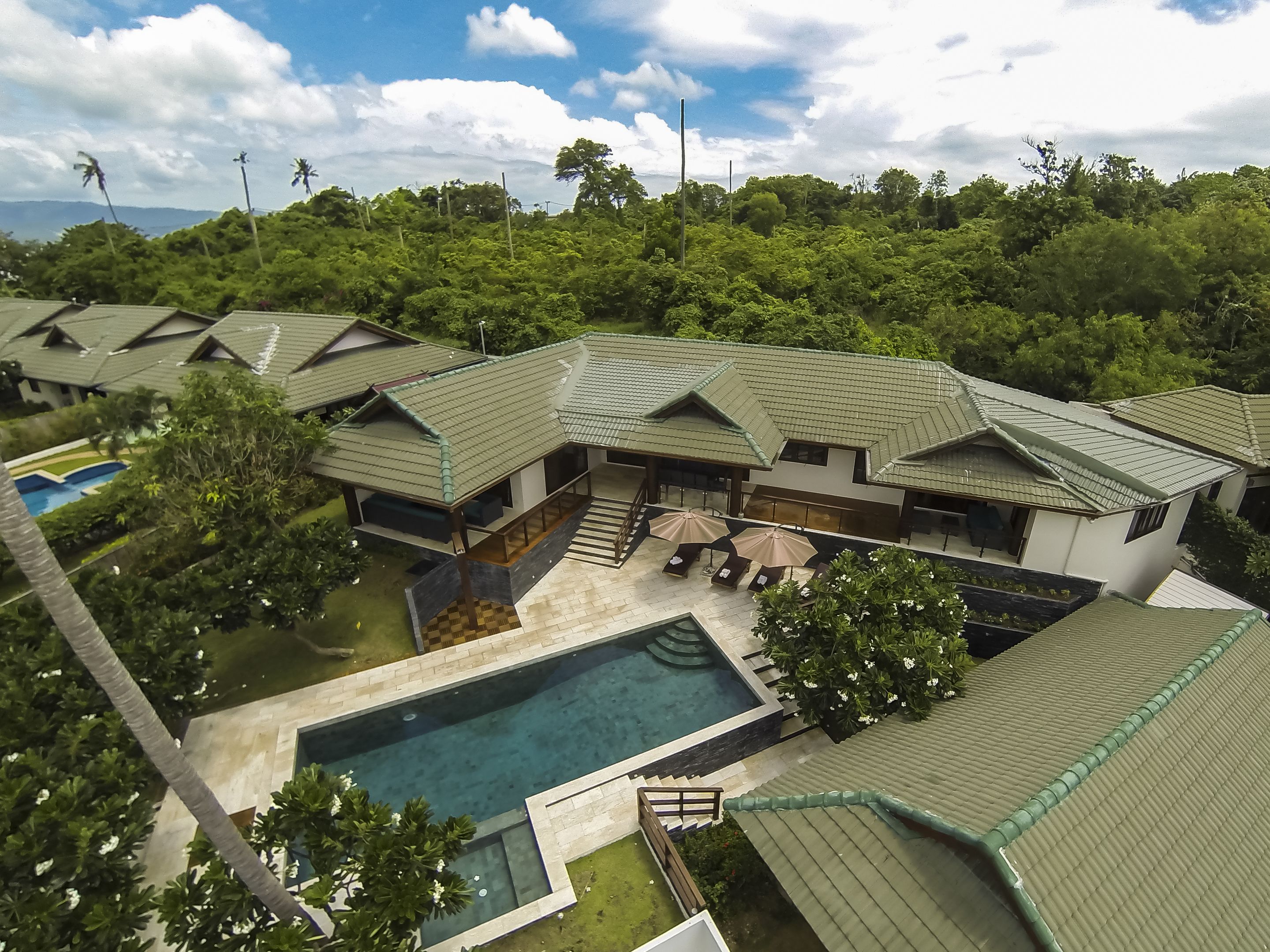 A resort with multiple villas, a swimming pool, and a landscaped garden.