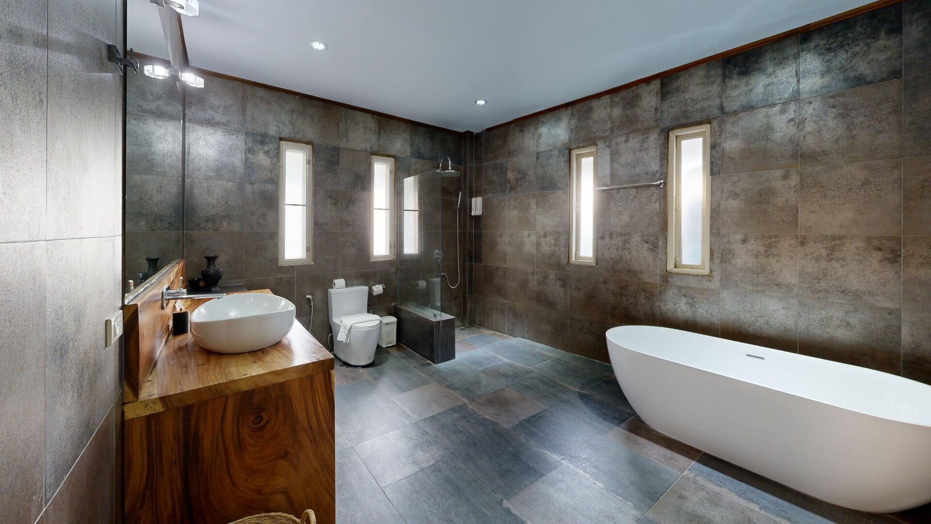 Une salle de bain moderne avec une baignoire sur pieds, un grand meuble-lavabo avec un lavabo en forme de coupe et une cabine de douche en verre.