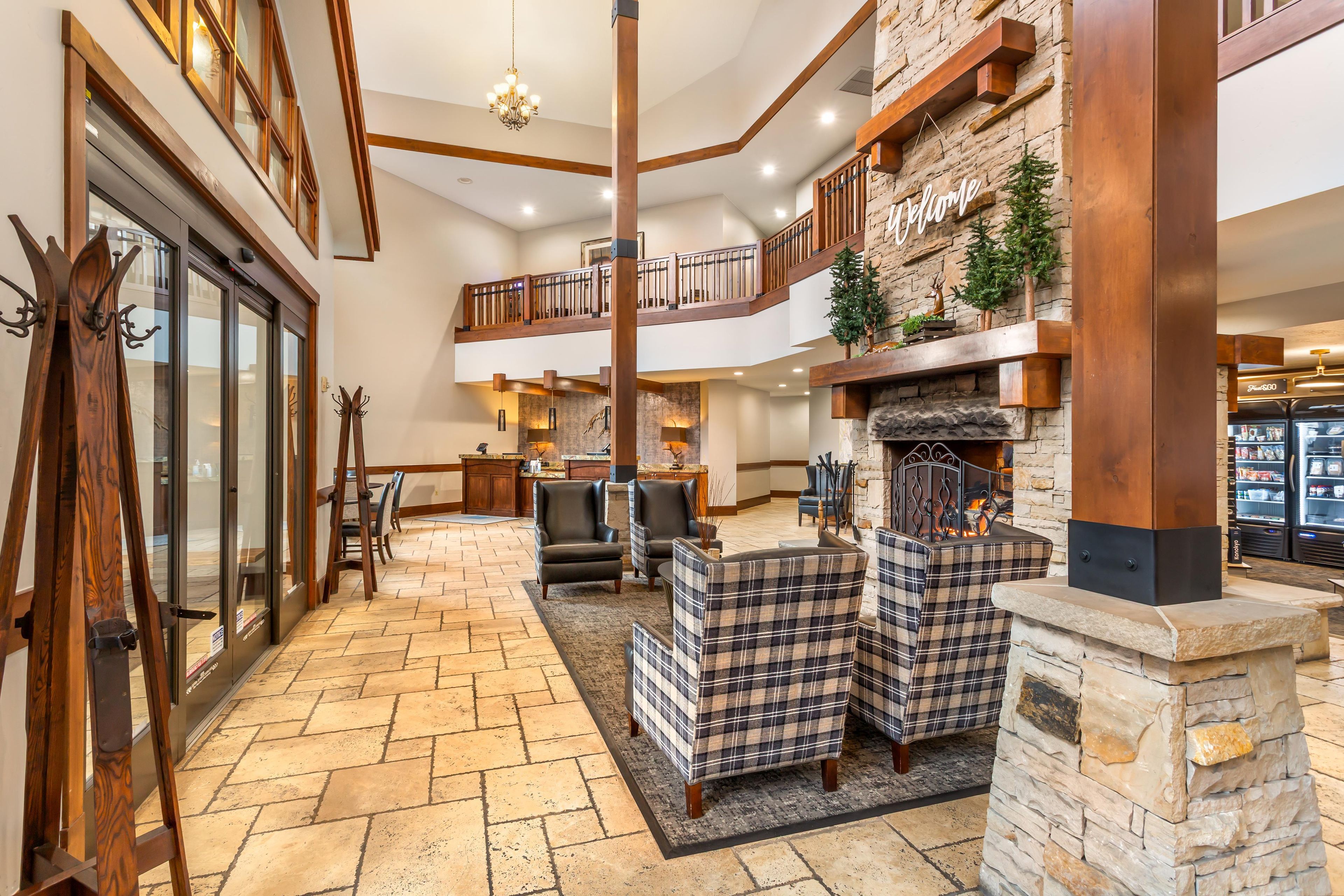 A spacious interior with a fireplace, seating area, and a view of the kitchen.