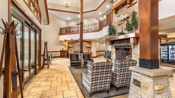 A spacious interior with a fireplace, seating area, and a view of the kitchen.