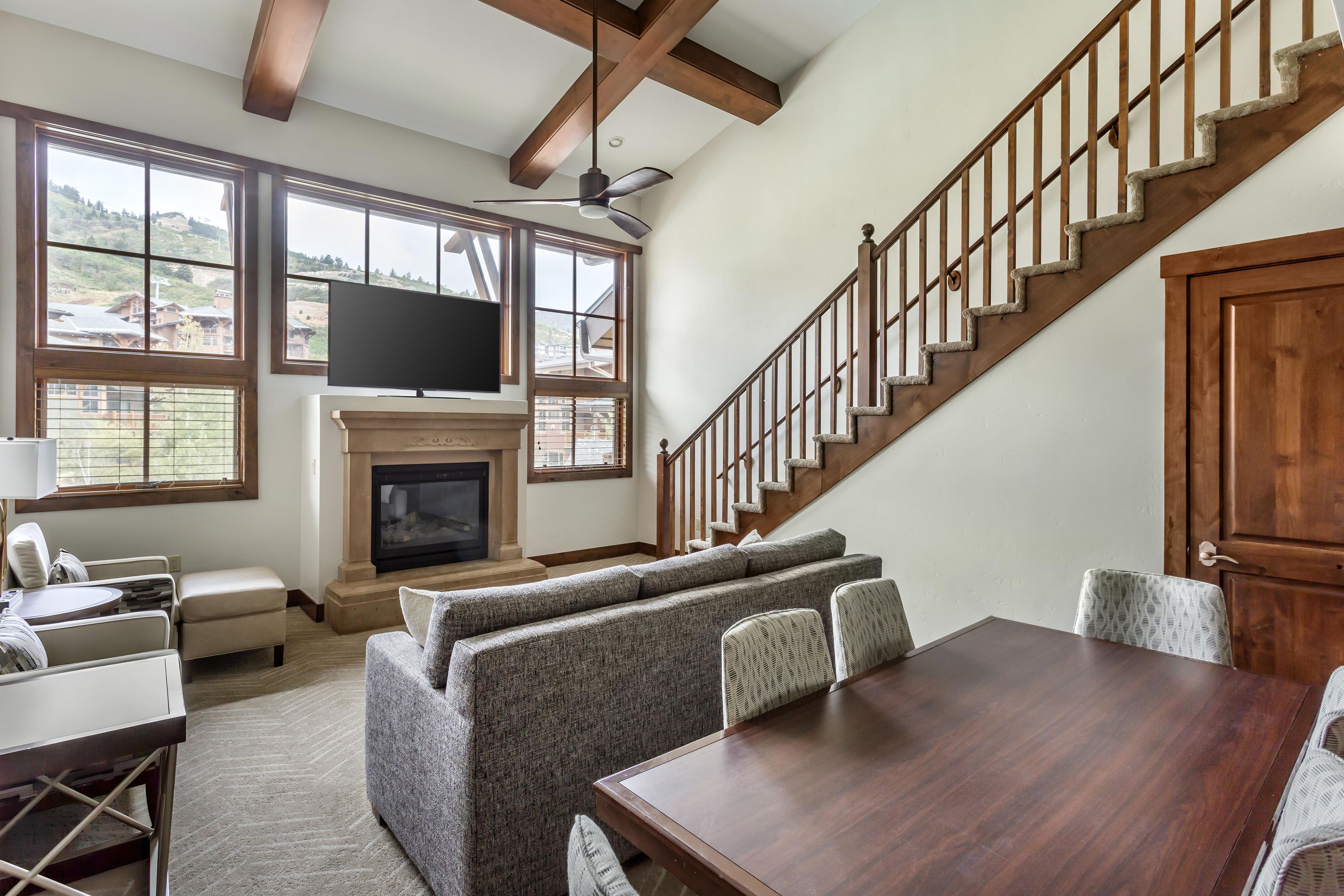A spacious living room with a fireplace, a television, and a dining area.