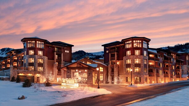 A multi-story hotel with a stone facade, multiple balconies, and a snow-covered landscape. - Hilton Grand Vacations Club Sunrise Lodge Park City (Park City)