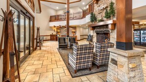 A spacious lobby with a stone fireplace, leather sofas, and a high ceiling with wooden beams. - Hilton Grand Vacations Club Sunrise Lodge Park City (Park City)