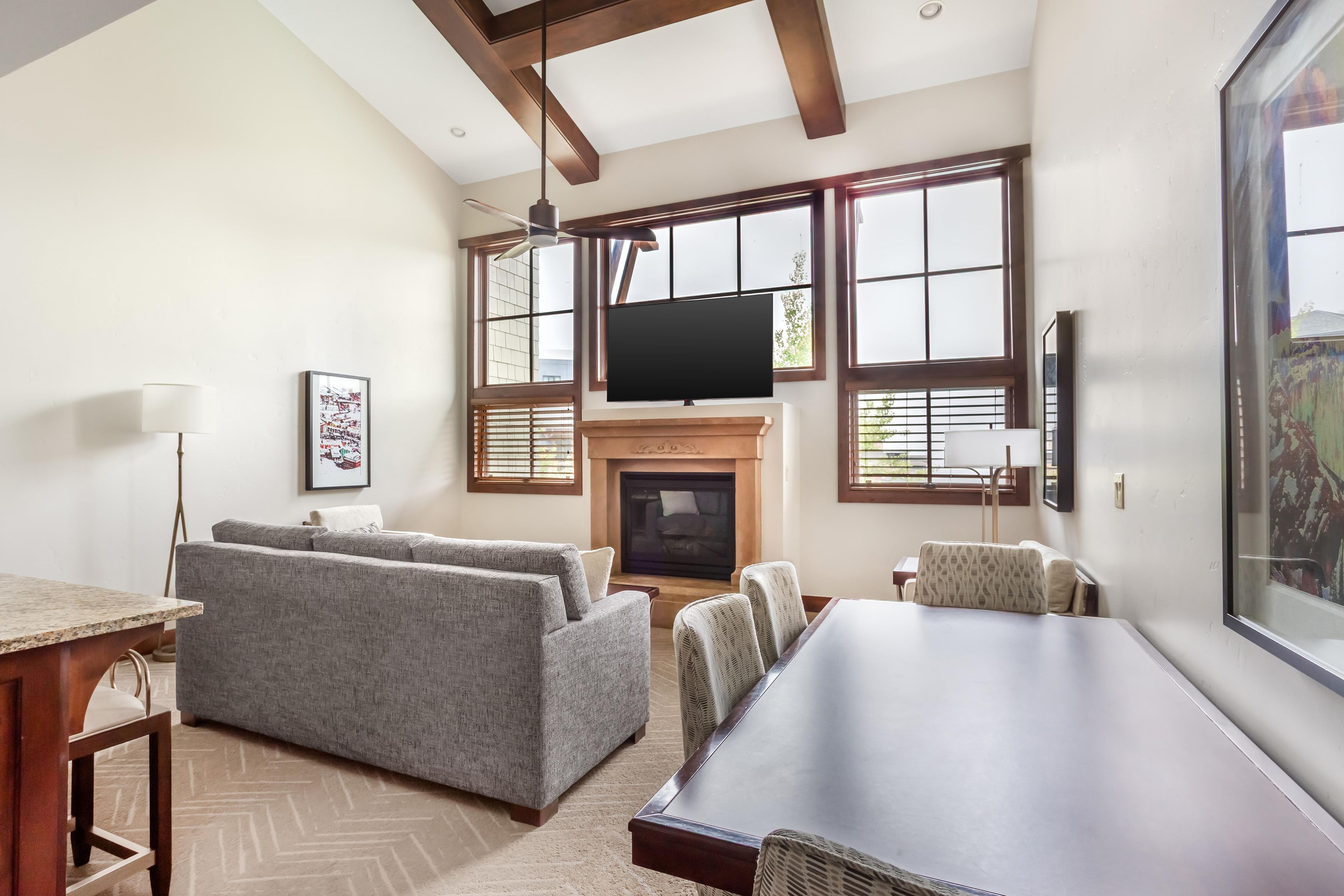 A living room with a fireplace, a large TV, and a dining area with a long table.