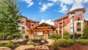A hotel with a stone facade, multiple balconies, and a sign indicating it's a Hilton Grand Vacations Club.