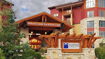 A hotel with a prominent entrance, a stone facade, and a sign indicating it's a Hilton Grand Vacations Club.