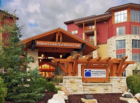 A hotel with a prominent entrance, a stone facade, and a sign indicating it's a Hilton Grand Vacations Club.