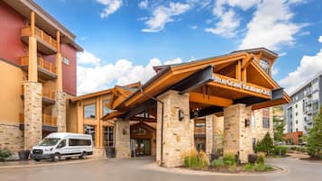 A hotel entrance with a covered walkway, stone pillars, and a sign for Hilton Grand Vacations Club.
