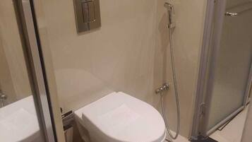 Baño con inodoro, bidé y ducha.
