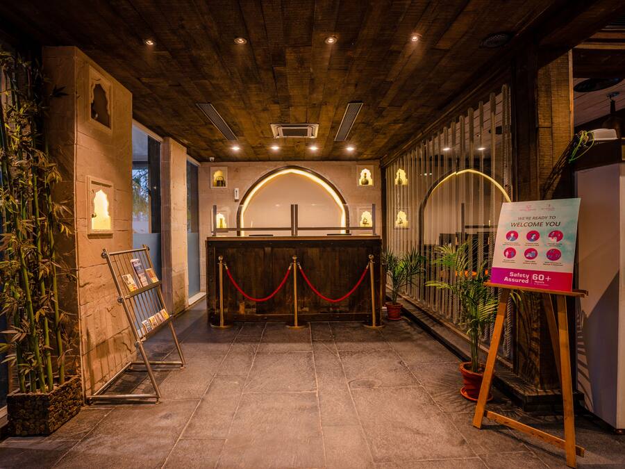 A reception area with a wooden ceiling, a reception desk, and a sign indicating safety assurance for ages 60+.