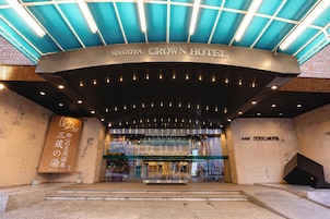 The entrance to Nagoya Crown Hotel with a modern design, featuring a curved entrance and illuminated signage.