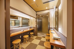 A hotel bathroom with a checkered floor, a mirror, a sink, and a shower stall. - Nagoya Crown Hotel (Nagoya)