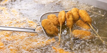 Primer plano de comida fritando en aceite caliente.