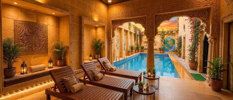 A spa area with wooden loungers, a pool, and decorative plants.