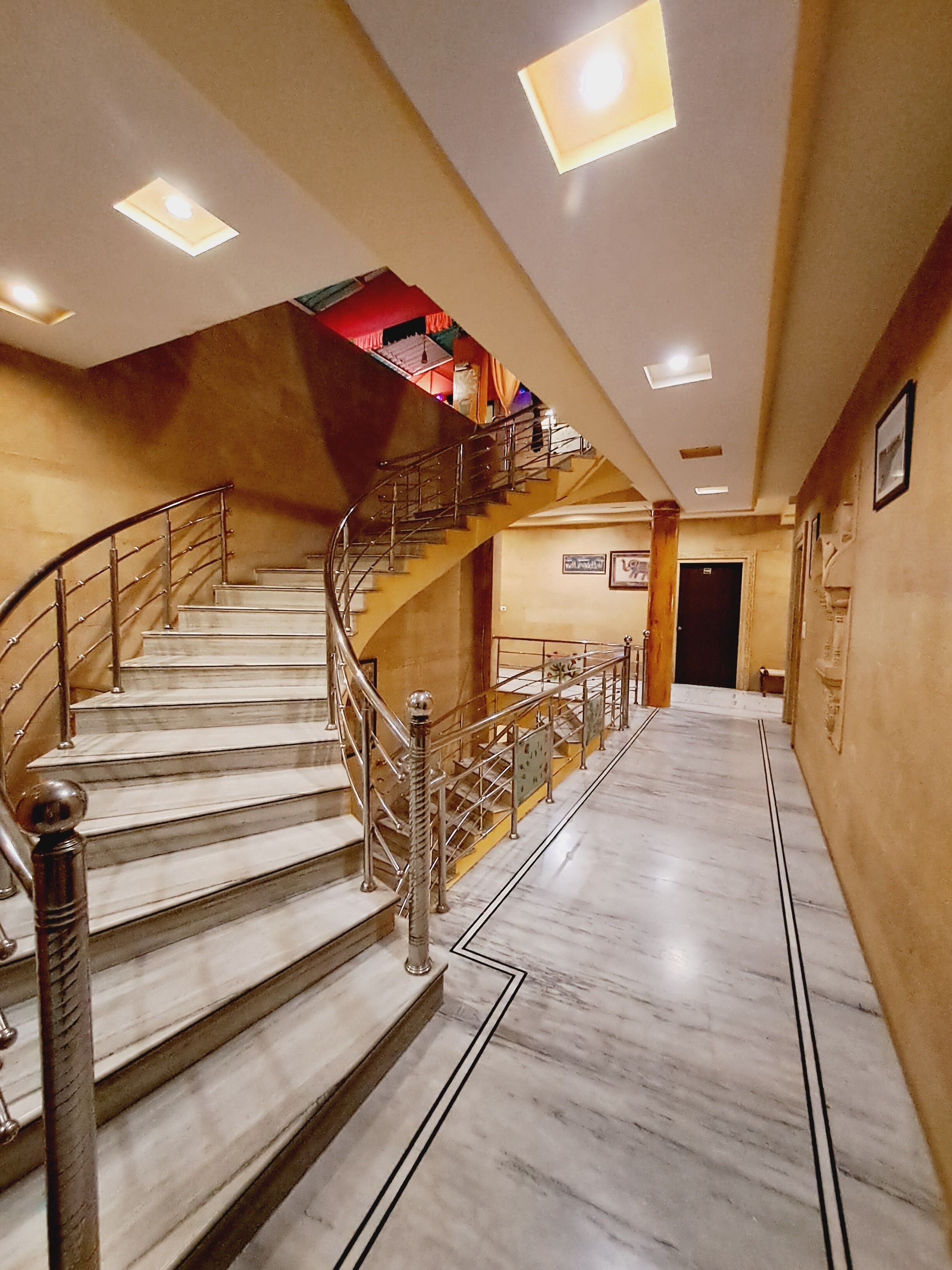 A marble staircase with metal railings leading to a second floor.