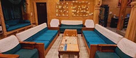 Una habitación tradicional con un conjunto de sofás, una mesa de centro de madera y un ventilador de techo.