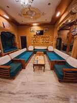 Una habitación tradicional con un conjunto de sofás, una mesa de centro de madera y un ventilador de techo.