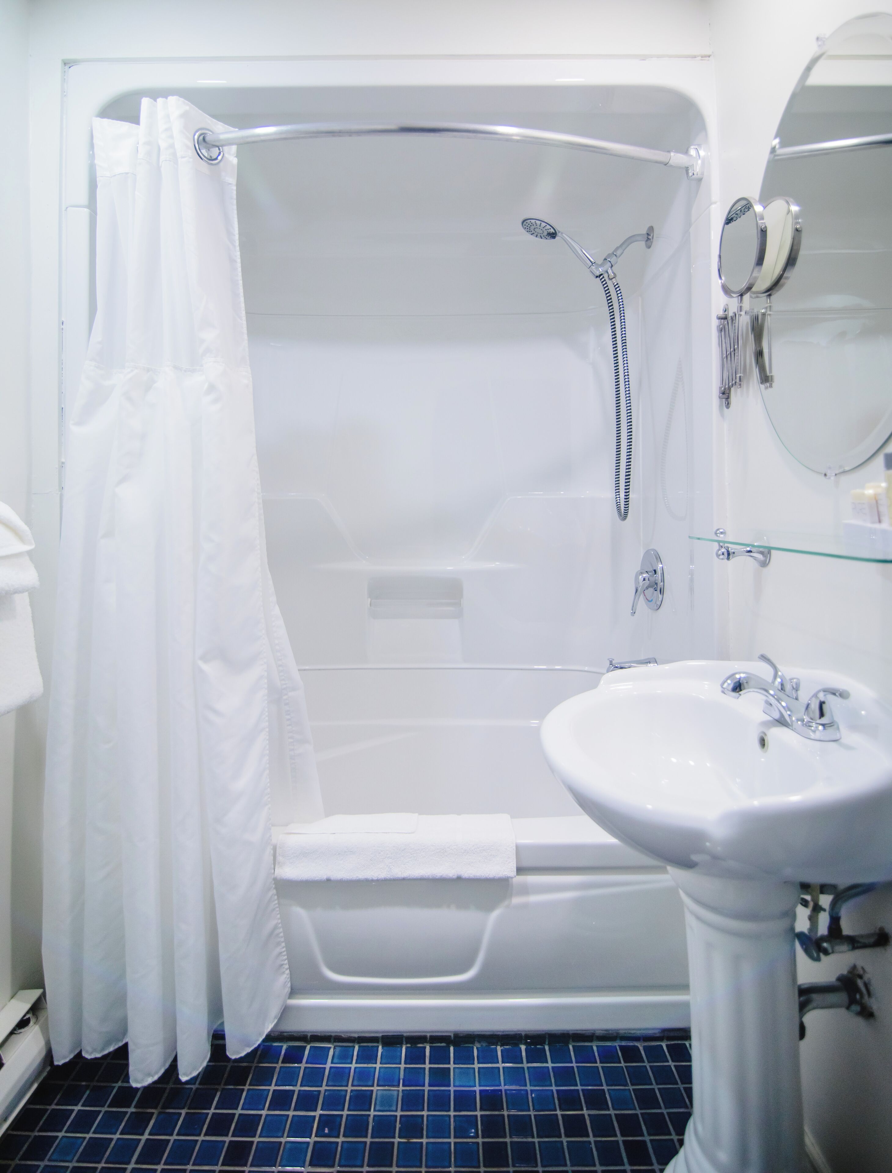 A bathroom with a bathtub, shower, and sink.