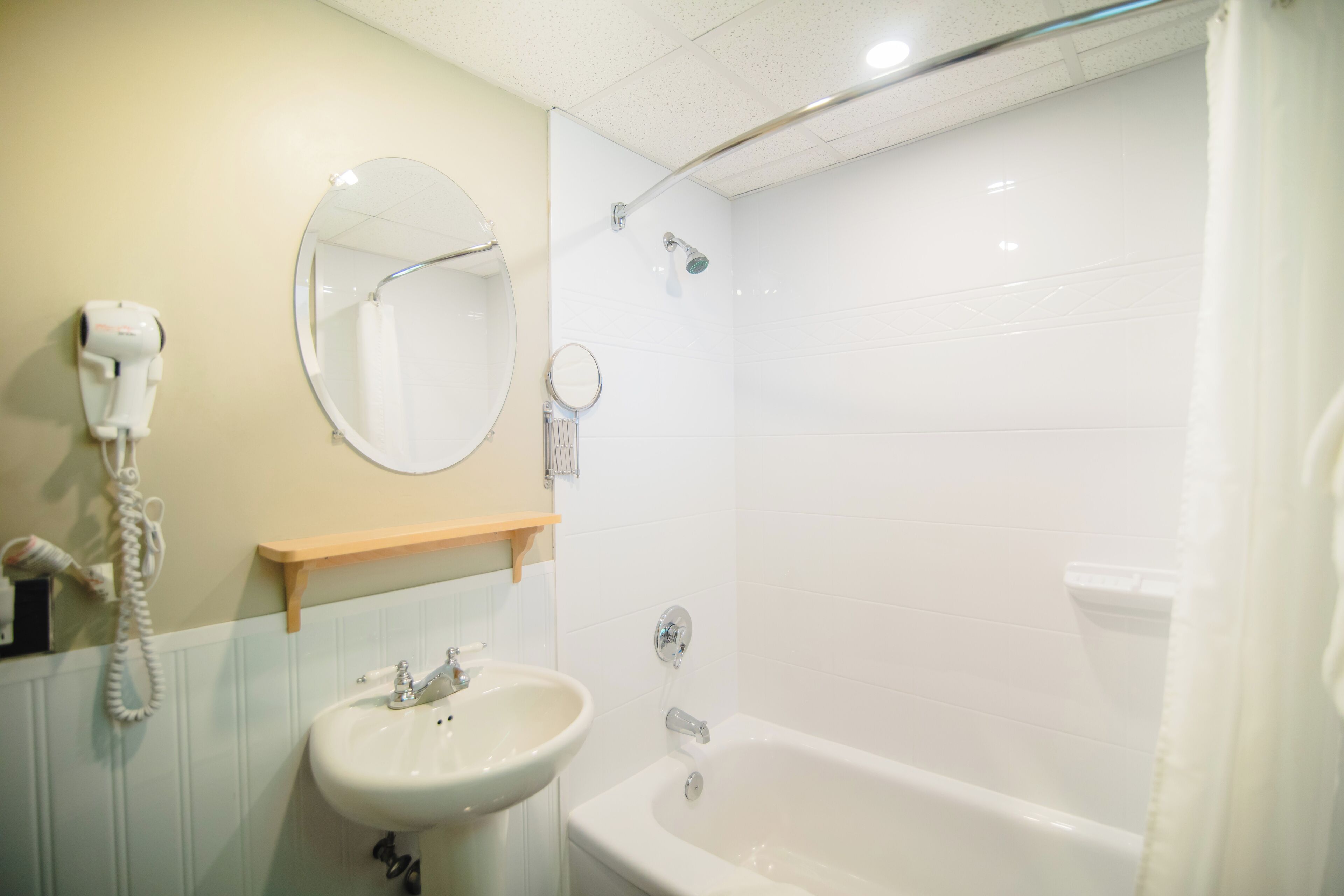 Ein Badezimmer mit Waschbecken, Spiegel und Dusche.