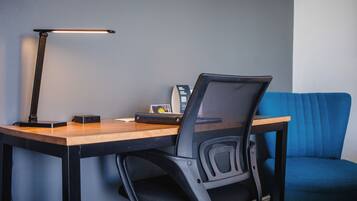 Een werkplek met een bureau, stoel en een blauwe bank.