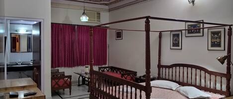 Une chambre à coucher avec un lit à baldaquin, un bureau avec une chaise, une armoire et un miroir.