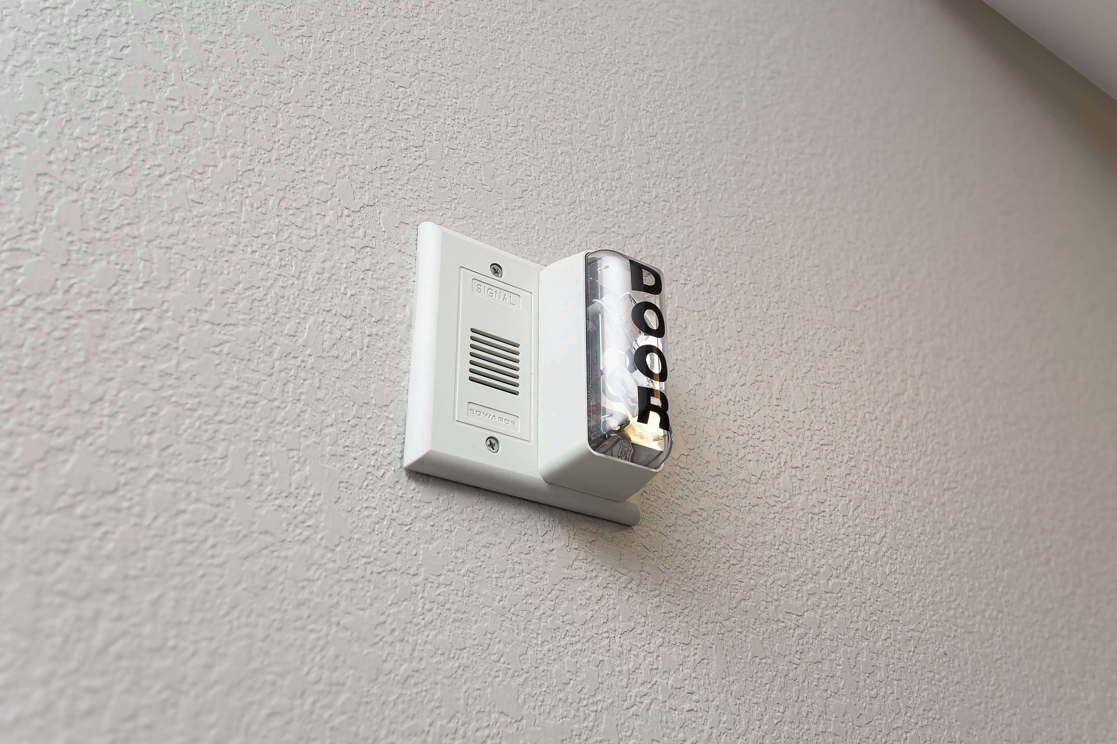 A wall-mounted intercom with a doorbell button.