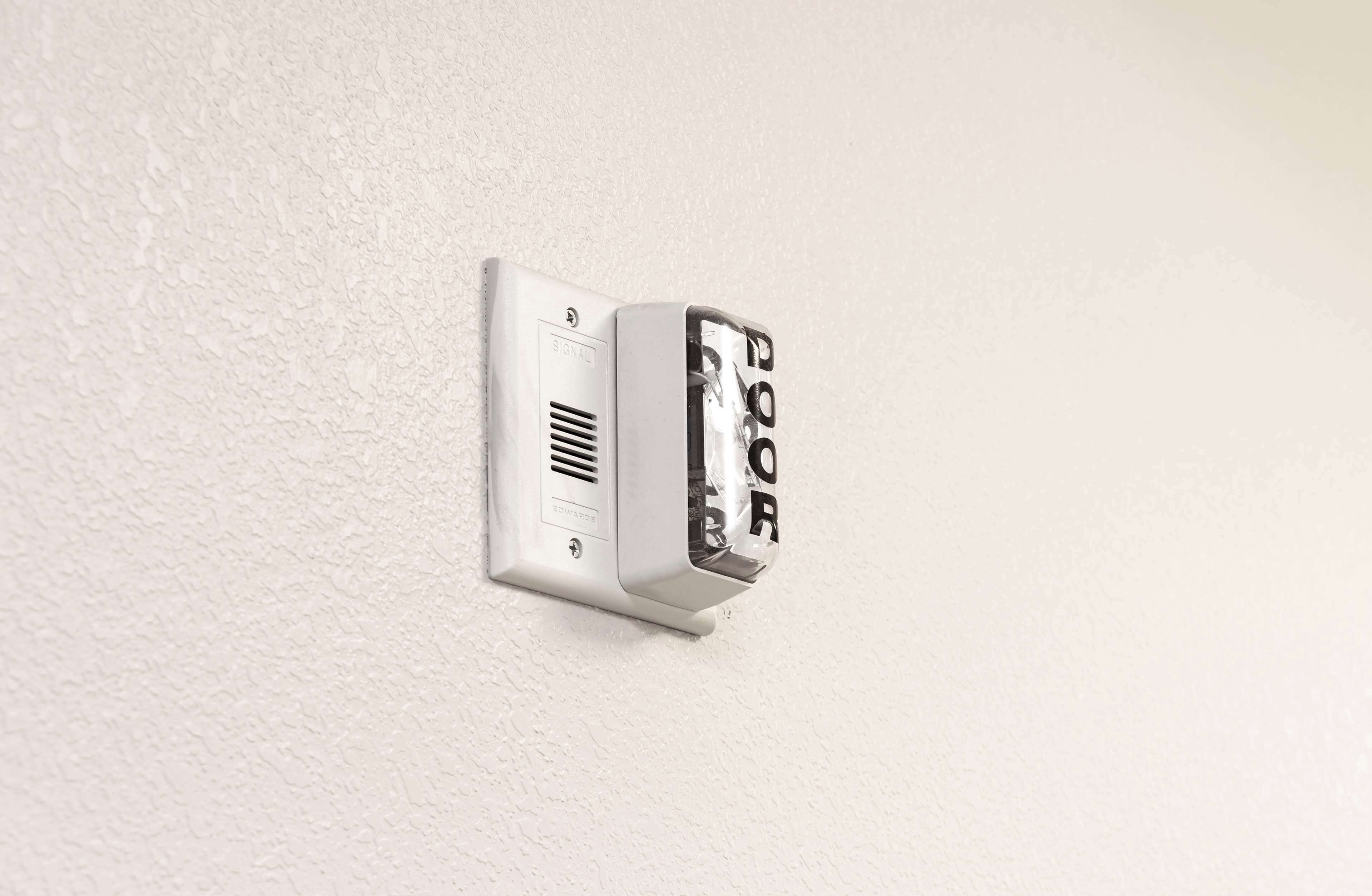 A wall-mounted intercom system with a keypad.